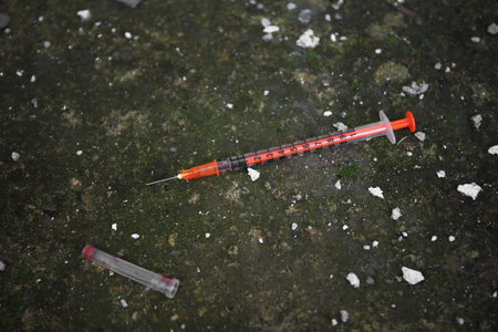 Empty disposable syringe with needle on streetの写真素材