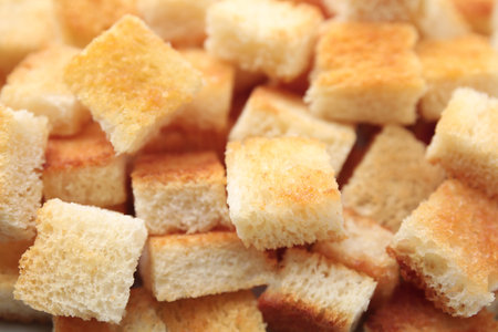 Delicious crispy croutons as background, closeup viewの写真素材