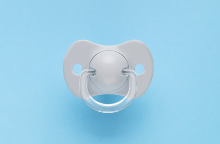 One new baby pacifier on light blue background, top viewの写真素材