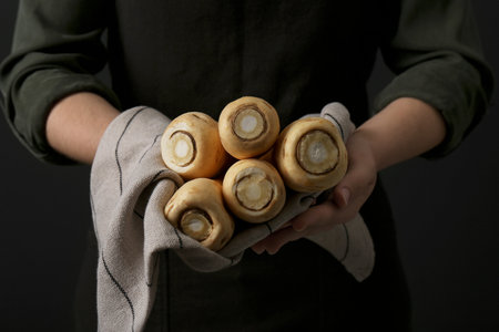 Woman holding fresh ripe parsnips on black background, closeupの写真素材