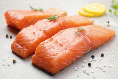 Fresh raw salmon and ingredients for marinade on light gray table, closeupの写真素材