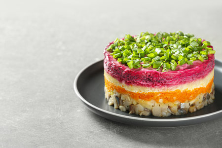Herring under fur coat salad on gray table, space for text. Traditional Russian dish