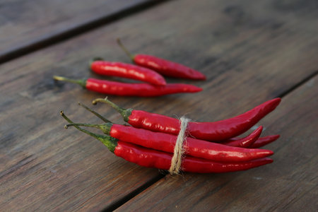 Fresh ripe chili peppers on wooden tableの写真素材