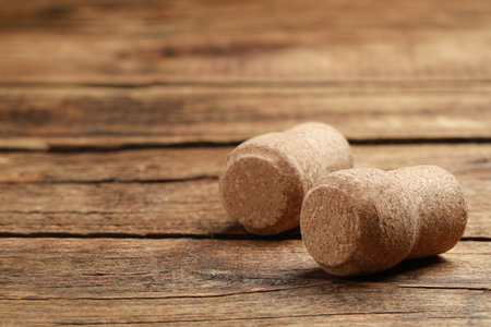Corks of wine bottles on wooden table, closeup. Space for text