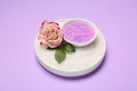 Aromatic sea salt and beautiful flower on purple backgroundの写真素材