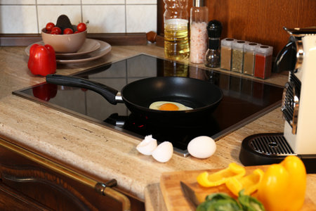 Frying eggs for tasty breakfast in the kitchenの写真素材