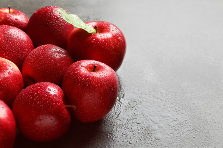 Fresh red apples with drops of water on tableの写真素材