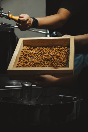 Man holding sieve with coffee beans indoors, closeupの写真素材