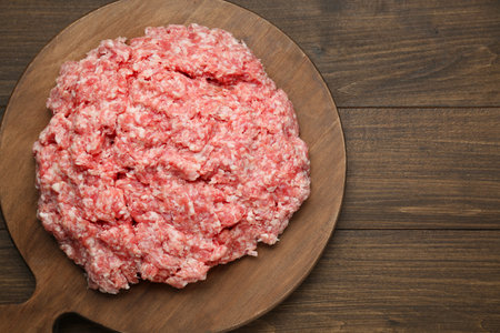Raw fresh minced meat on wooden table, top view. Space for textの写真素材