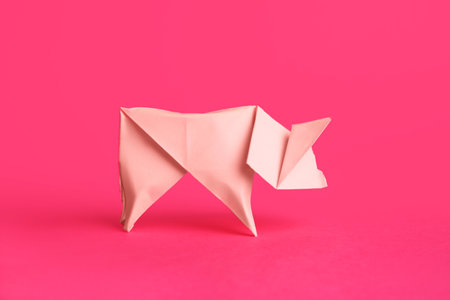 origami art. Handmade bright paper pig on pink backgroundの写真素材