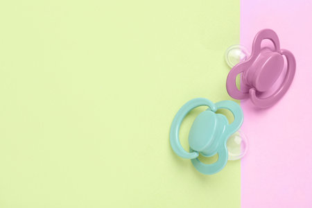 Baby pacifiers on color background, top view. Space for textの写真素材
