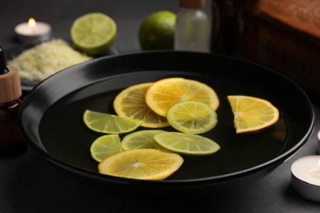 Bowl of essential oil and lemons on gray table, closeup. Aromatherapy treatmentsの写真素材