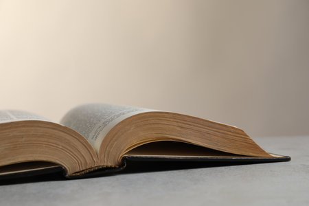Open hardcover Bible on light gray table, closeup with space for text. religious bookの写真素材