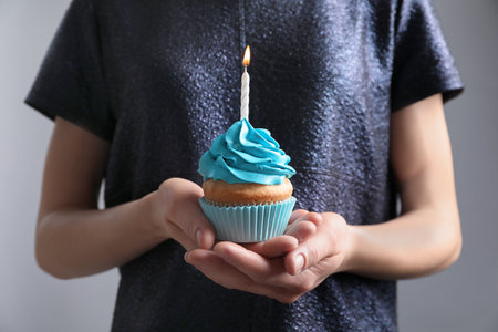 Woman holding birthday cupcake, closeupの写真素材