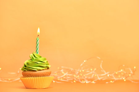 Birthday cupcake with candle on color backgroundの写真素材