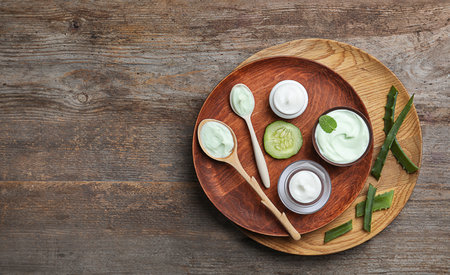 Composition with body cream in jars on wooden background, top viewの写真素材