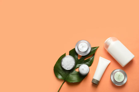 Different skin care cosmetic products with green leaf on color background, top viewの写真素材