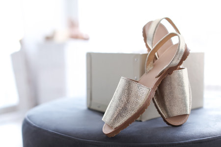 Female shoes on pouf in store
