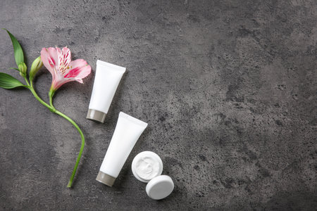 Flat lay composition with body care cosmetics and flower on gray backgroundの写真素材