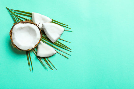 Ripe coconut with leaf on color backgroundの写真素材