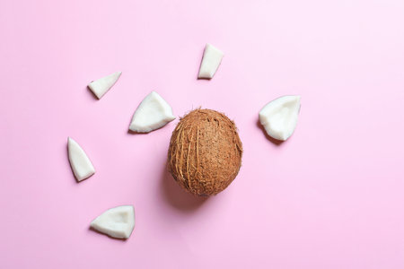 Whole coconut with pieces on color backgroundの写真素材