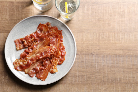 Plate with fried bacon on wooden backgroundの写真素材