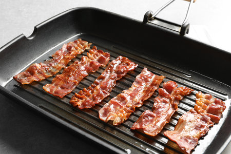 Grill pan with bacon on tableの写真素材