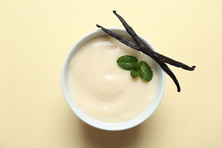 Vanilla pudding, sticks and fresh mint on color backgroundの写真素材