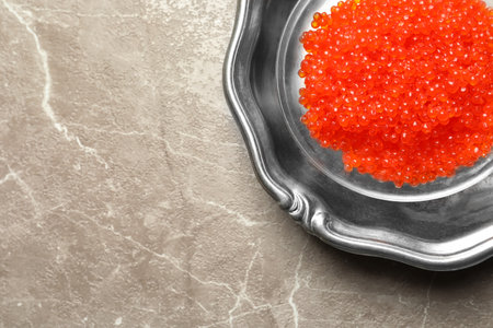 Dish with delicious red caviar on color backgroundの写真素材