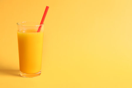 Glass of orange juice on color backgroundの写真素材