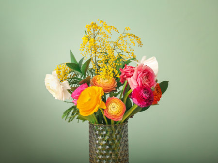Vase with beautiful ranunculus flowers on color backgroundの写真素材