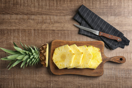 Cut fresh pineapple on wooden boardの写真素材