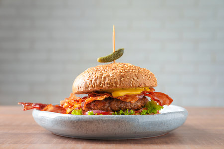 Tasty burger with bacon on plateの写真素材