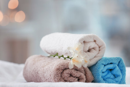 Towels and flowers on massage table in spa salonの写真素材