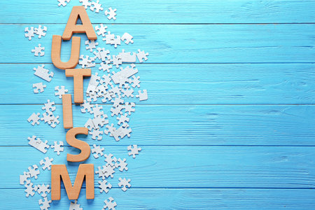 Word AUTISM made with letters with puzzles on wooden backgroundの写真素材