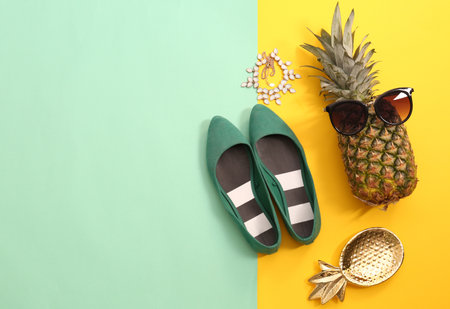 Flat lay composition with ripe pineapple, sunglasses and shoes on color backgroundの写真素材
