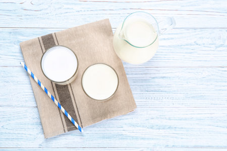 Glassware with milk on wooden table. fresh dairy productsの写真素材