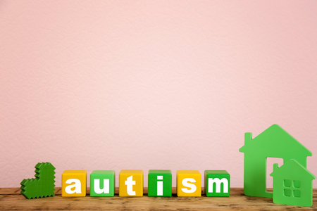 Wooden houses and cubes with word "Autism" on tableの写真素材