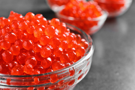 Glass bowl with delicious red caviar on table, closeupの写真素材