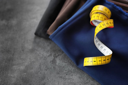 Fabrics and measuring tape for tailoring on gray backgroundの写真素材