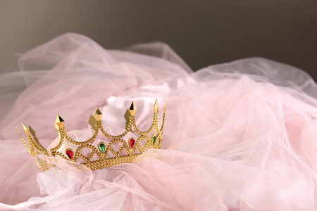 Beautiful gold tiara with gems on light cloth. Space for textの写真素材