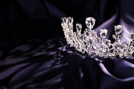 Beautiful silver tiara with diamonds on dark cloth. Space for textの写真素材