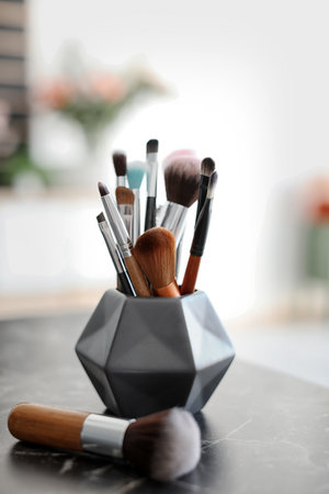 Holder with makeup brushes on tableの写真素材