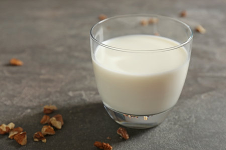 Glass with milk and nuts on gray backgroundの写真素材