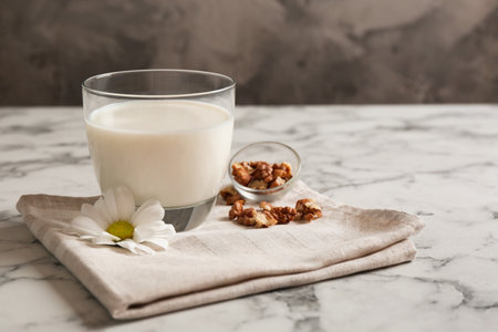 Glass with milk and nuts on tableの写真素材