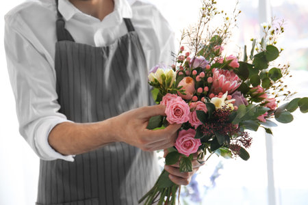 Male florist creating beautiful bouquet, closeupの写真素材