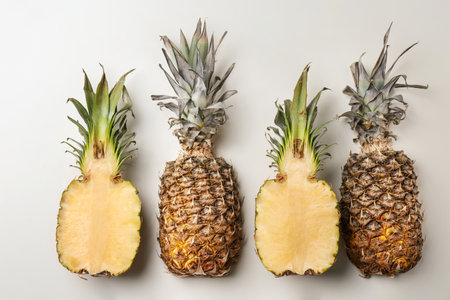 Fresh pineapples on light background, flat layの写真素材
