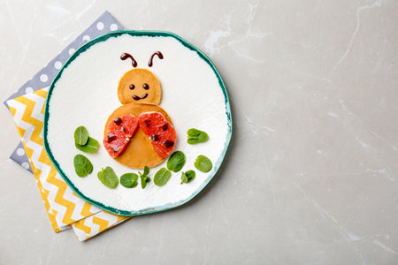Funny pancakes for kids breakfast on table, top viewの写真素材