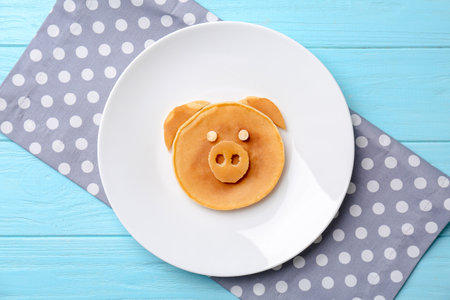 Funny pancake for kids breakfast on wooden table, top viewの写真素材