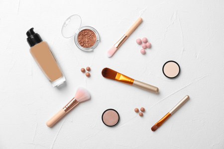 Flat lay composition with cosmetic products and makeup brushes on light backgroundの写真素材